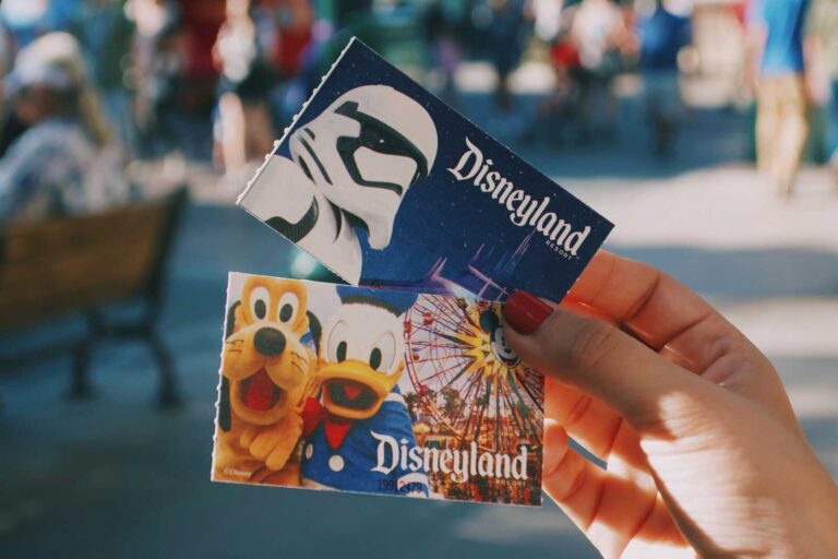 Disneyland tickets held in hand as an example of Christmas experience gifts for travel-loving families.