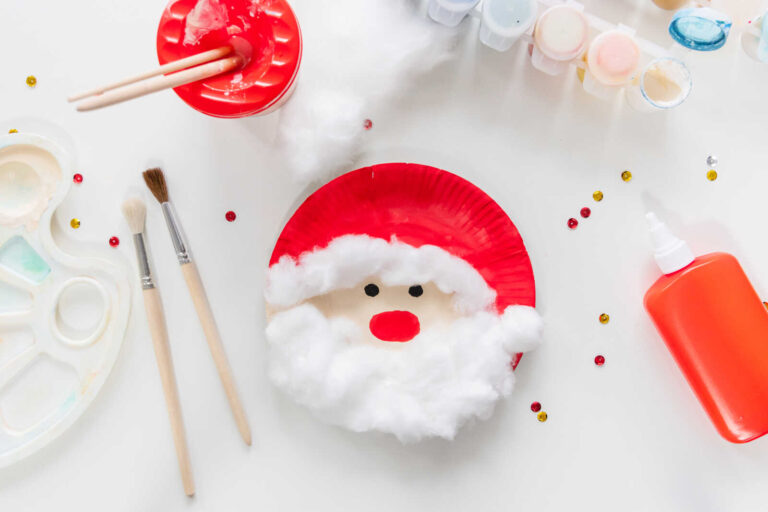 Finished paper plate Santa craft with fluffy cotton beard and red painted hat for kids.